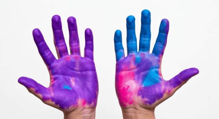 Purple and blue painted hands with colorful tie-dye effects.
