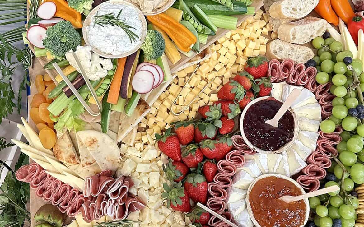 A grazing table spread of cheeses, fruit, and charcuterie